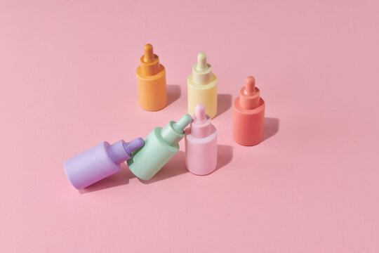 Creative photo of cosmetic bottle with pipette on a pink background 