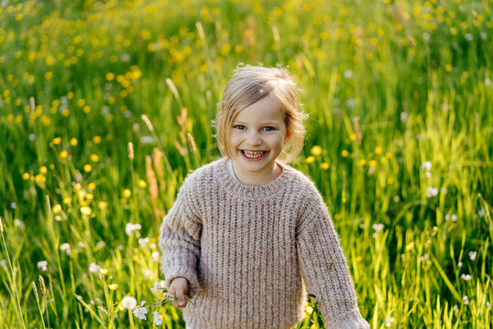 Smiling child standing in grassy field