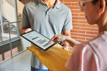 Female client confirming parcel delivery near apartment