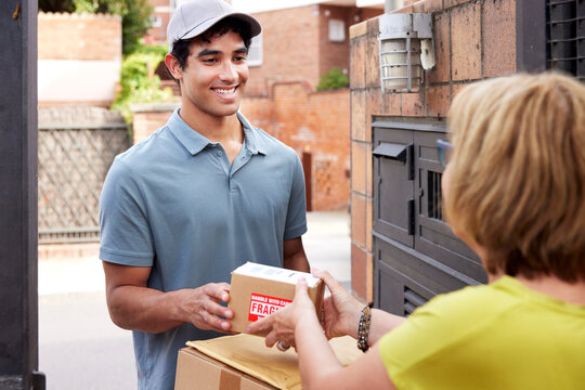 Happy courier delivering fragile parcels to woman