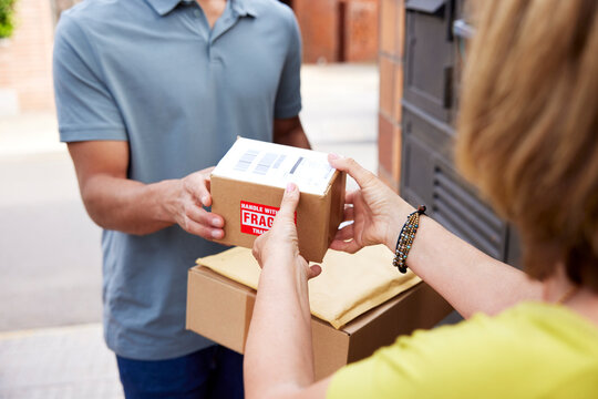 Cropped female customer receiving fragile parcel