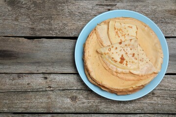 Delicious crepes on wooden table, top view. Space for text