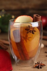 Hot mulled cider on wooden table, closeup