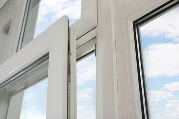 Open window with white plastic frame indoors, low angle view