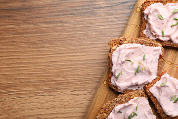 Tasty sandwiches with cream cheese and thyme on wooden table, flat lay. Space for text