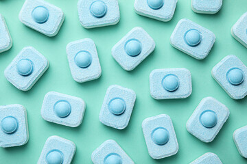 Water softener tablets on turquoise background, flat lay