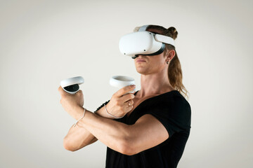 Young man using virtual reality headset. Isolated on gray background.