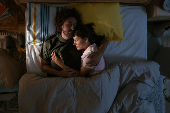 Woman and man sleeping in bed at night