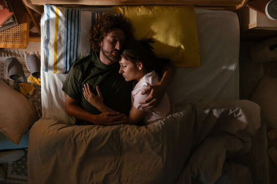 Woman and man sleeping in bed at morning light