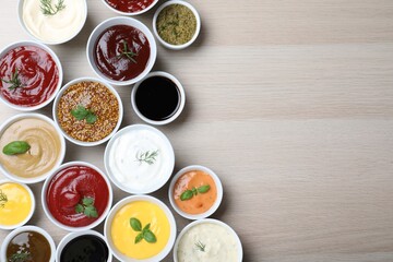 Fototapeta na wymiar Many different sauces and herbs on wooden table, flat lay. Space for text