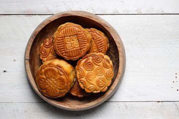 Moon cake Mooncake table setting - Round shaped Chinese traditional pastry with tea cups on wooden background, Mid-Autumn Festival concept, close up.