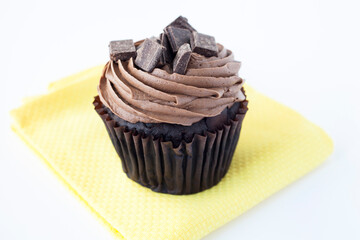 Chocolate Cupcake with Chocolate Frosting on Yellow Napkin