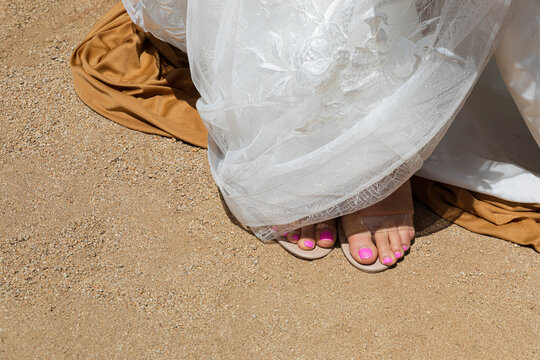 bride with sandals and pink painted nails wearing a wedding dress