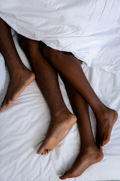 Cuddling legs under white sheet
