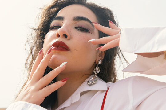 Beautiful young girl with long black hair wearing red dress in nature