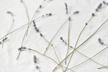 Lavender flowers scattered on linen tablecloth.