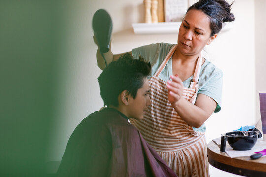Woman with dye drying her son's hair