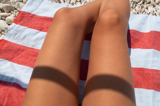 tanned sexy legs detail on a beach towel