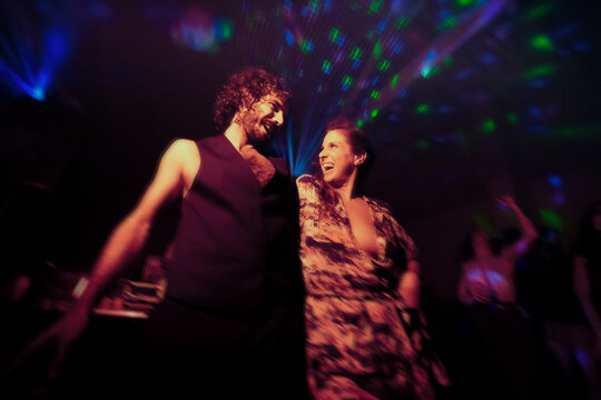 Dancing lovers full of joy at night party