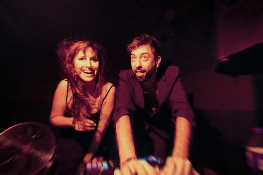 Cheerful deejay couple in action during night session