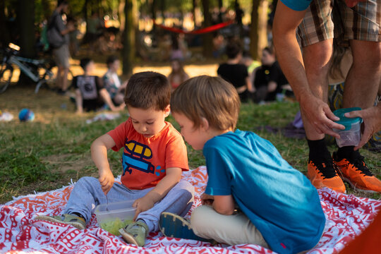 Children are having a healthy snack while eating outdoors on a picnic