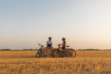 Two mountain bikers on wheat fields