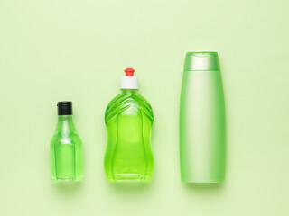 A set of three bottles of detergents on a green background. Cleaning kit.