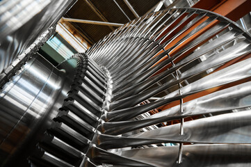 Shiny rotor of powerful steam turbine in light workshop