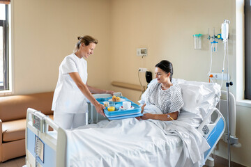 Nurse providing food to a patient in hospital