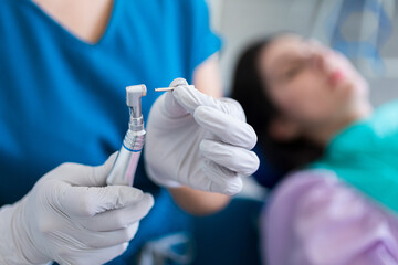 Dentist putting a brush on a metal instrument