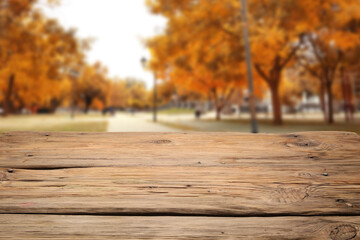 Naklejka na ściany i meble Empty wooden table in beautiful autumn city park