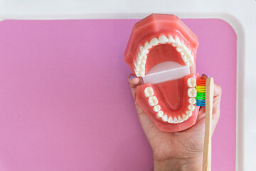 Female hand showing how to brush teeth 