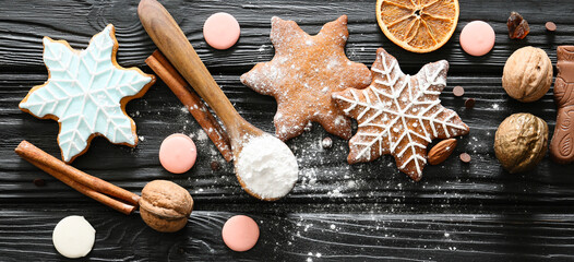 Composition with tasty Christmas cookies on black wooden table, top view