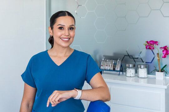 A smiling female dentist in blue uniform in a dental clinic 