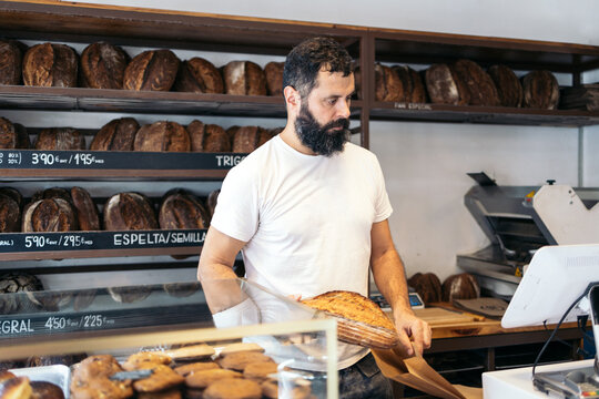 Baker selling bread in his business