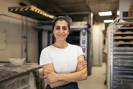 Artisan baker posing in the kitchen of her business