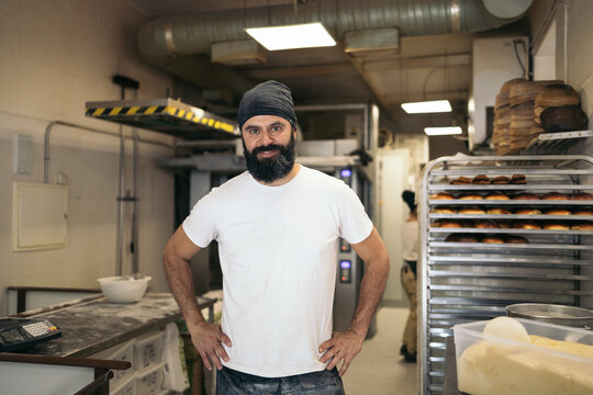 Portrait of cheerful bread maker in the bakehouse