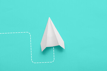 Paper plane on turquoise background