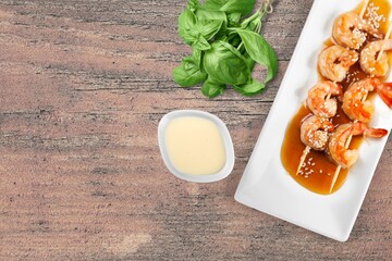 Grilled shrimps with sauce and fresh herbs. Shrimps on grill in summer menu. Seafood skewer in minimal style