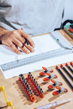 Detail of engineer hands drawing plans with ruler.