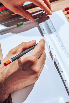 Detail of engineer hands drawing plans with ruler.