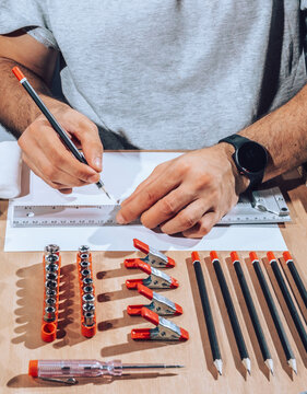 Detail of engineer hands drawing plans with ruler.