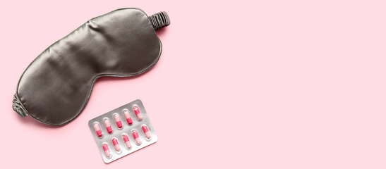 Sleep mask and pills on pink background with space for text