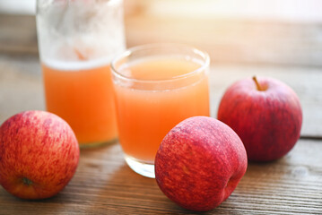 apple cider vinegar natural remedies and cures for common health condition,  raw and unfiltered organic apple cider vinegar in glass with apple fruit on the wooden table