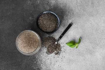 Glass of water with chia seeds on black and white background