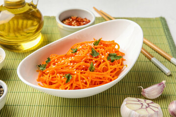 Bowl with delicious carrot salad and ingredients on table