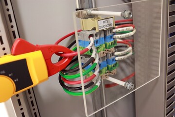 Action of using amp meter to measure current power electric and check the operation of the system....