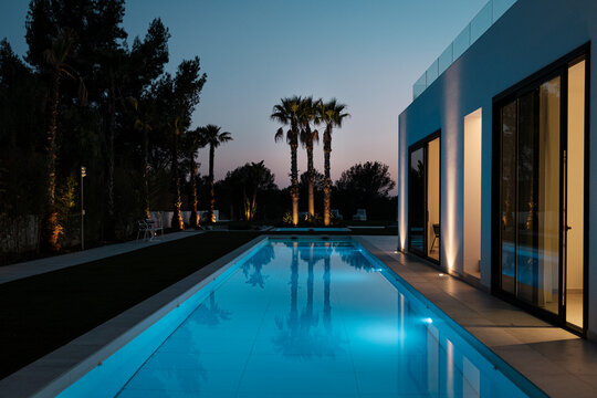 Luxury villa with pool lighted at night