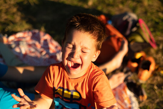 A close-up portrait of a crying toddler taken outdoors in afternoon
