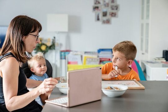 Mom eating while her son does his homework